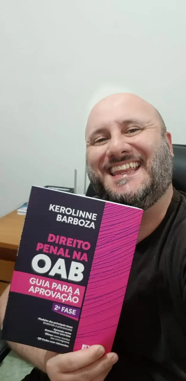 Aluno segurando o livro de Direito Penal para a OAB